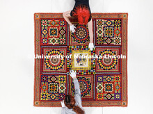 Student workers Olivia Fiore, top and Inas Hskan, smooth a quilt on a large table so it can be photo
