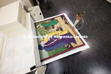 Sarah Walcott, collections manager, looks over the Ruth and Naomi Quilt sewn by Charles Pratt in the
