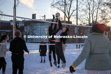 Two students meet at the net to hit the ball while playing volleyball with a big group of friends Th