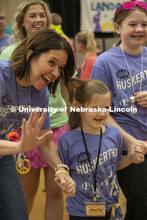 Evelyn Greisen smiles with her mother during Miracle Kid procession at Huskerthon 2023. University o