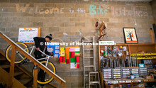 Engineering student Jacob Dalton carries a bike down from storage at Lincoln Bike Kitchen Repair. Th