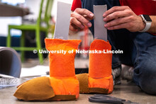 Sophomore emerging media arts major Isaiah Griffith glues foam onto the feet of a puppet for his fin
