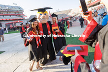 Herbie Husker poses with graduates Saturday. Undergraduate commencement at Memorial Stadium. May 20,
