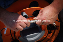 Christopher Charroin connects monitor cables that will be used to record data from a test of a sled 