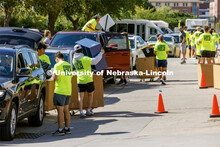 The Student Move-In Team swarms the line of cars outside Abel Residence Hall to unpack their belongi