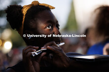 Tori Thomas watches Tony Falcone direct the band as the sun dapples her face through the trees. The 