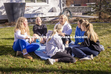 Kappa Kappa Gamma Sorority sisters sit outside on their front lawn chatting. February 20, 2024. 