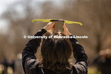 A student shoots a photo of the eclipse through specialized glasses during the "Solar Social" event 