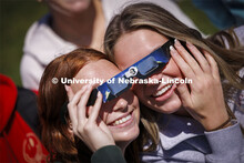 Maddie Dorn and Emily Pals share their glasses to watch the eclipse. The Solar Social party to view 