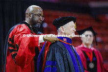 Larry Johnson is hooded by Chancellor Rodney D. Bennett after Johnson has awarded an honorary degree