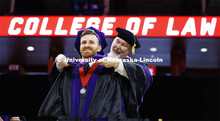 Peter Biedenweg receives his hood. College of Law commencement in Devaney on the volleyball court. M
