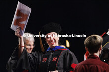 Doctoral candidate Renca Dunn holds up her diploma after her doctoral hooding. Graduate Commencement