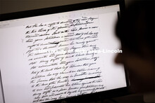 A student transcribes writing on an old legal document. Students in Research Experiences for Undergr