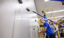 John Griffiths rolls on the paint along with his fellow 1L students. The first-year College of Law s