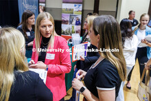 Tori Honn (left), a sophomore Animal Science major talks with Ellie Wanek from Merck Animal Health a