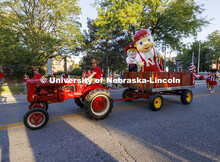Husker cheer coach Jake Jundt pulls Herbie Husker and Lil’ Red using his family’s tractor and wa
