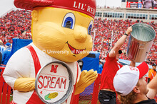 Lil Red holds a trash can lid saying “scream” at the Nebraska vs UCLA football game. November 2,