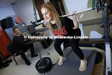 Anna Zingler pushes against a pressure plate under her feet while performing a squat against a rigid