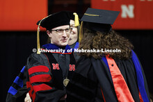 Connor Hines is congratulated by Professor Nicole Buan after Hines received his doctor hood. Graduat