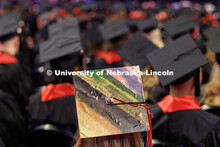 Emily Schmeling listens to speeches while wearing a decorated mortar board she painted over. Winter 