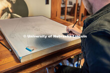 Nebraska's Scott McDonald draws at the desk in his home studio. McDonald works as a custodial manage