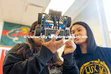 Lily Tran (right) and another Lincoln High student examine the robot to troubleshoot why one wheel i