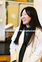 University of Nebraska–Lincoln undergraduate Chanasei Ziemann, poses in lab coat for a photo in Lu