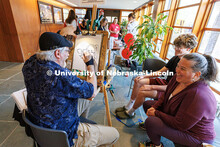 Amanda and Emmitt Perryman laugh as Kirk Kuenzi, a local artist, draws a caricature of them during a