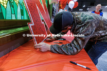 Admitted Students sign their name on a large "N" poster during Admitted Student Day. The event featu
