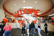 Admitted students and their parents walk under a welcoming balloon arch in the Nebraska Union and vi
