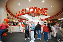 Admitted students and their parents walk under a welcoming balloon arch in the Nebraska Union and vi