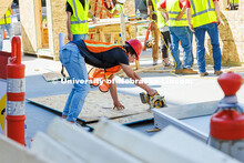 Nick Loibl, a junior Construction Management major, saws into a plank of wood during shed building d