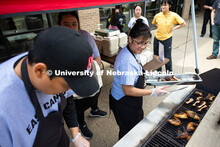 Marilou Wyatt, East Campus Dining Services production manager, uses tongs to put pork ribs on the gr