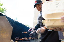 Franklin Yankton holds a piece of chicken steady on a spatula as he moves it from the grill to a to-