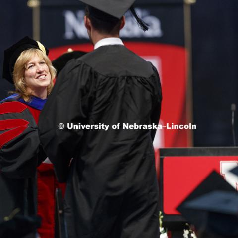 College of Business Interim Dean Kathy Farrell awards diplomas to business graduates. Students received their undergraduate diplomas Saturday morning in Lincoln's Pinnacle Bank Arena. 2452 degrees were awarded Saturday morning. May 6, 2017. Photo by Craig
