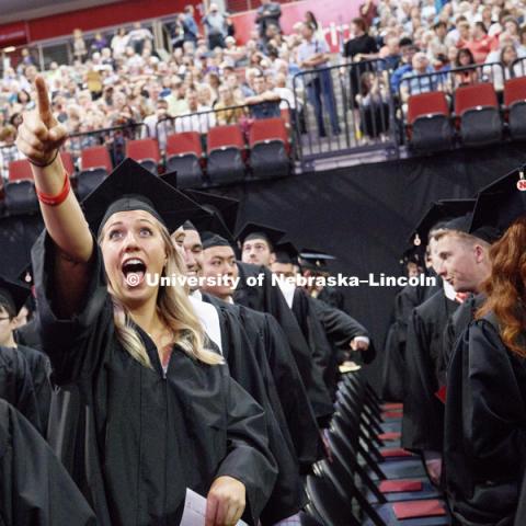Mary Frigo points to her family as the College of Business graduate stands to proceed to the stage. Students received their undergraduate diplomas Saturday morning in Lincoln's Pinnacle Bank Arena. 2452 degrees were awarded Saturday morning. May 6, 2017.