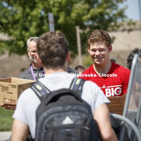 Thomas Lilly smiles as his roommate Luke Haberman walks backwards as they carry their futon into Schramm Hall. Residence Hall Move In on city campus Harper Schramm Smith Residence Halls. August 17, 2017. Photo by Craig Chandler / University Communication.