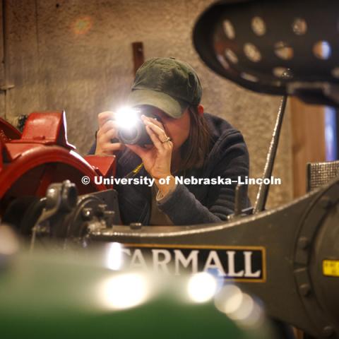 Callie Austad, a senior from Omaha, photographs in the museum. Students in Jamie Loizzo's ALEC 240 - Digital Photography and Visual Communication for Agriculture and the Environment practice their photography during a field trip to the Larsen Tractor Test