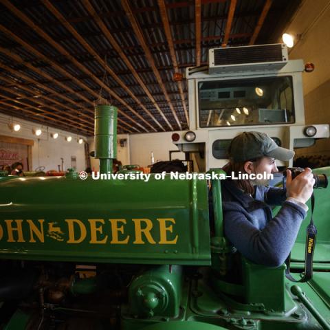 Callie Austad, a senior from Omaha, composes a photo of a John Deere tractor. Students in Jamie Loizzo's ALEC 240 - Digital Photography and Visual Communication for Agriculture and the Environment practice their photography during a field trip to the