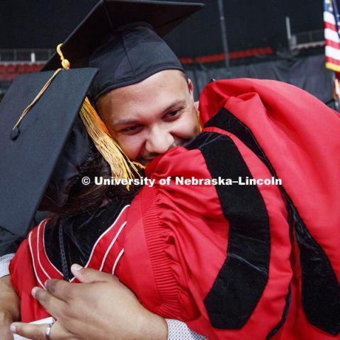 Clearthur Mangram gives assistant marshal Kara Brant a hug as he walks off stage. Summer Commencement at Pinnacle Bank Arena. August 11, 2018. Photo by Craig Chandler / University Communication.