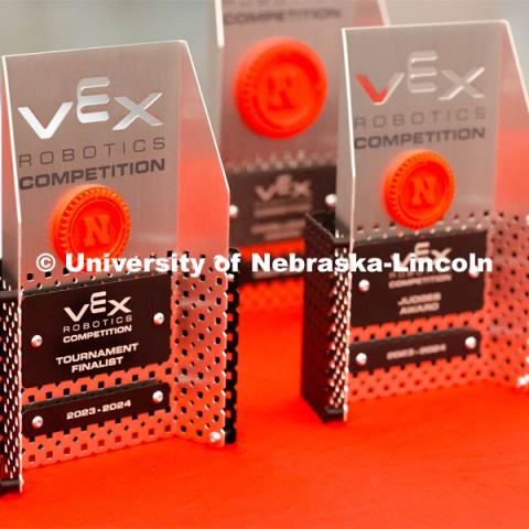 Competition trophies are lined up on a table. 2024 VEX Robotics Outreach Tournament hosted in Kiewit Hall. February 10, 2024. Photo by Taryn Hamill for University Communication and Marketing.