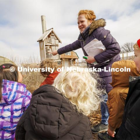 Madeline Williams talks to the children about a bug house in the Backyard Farmer Garden. Students in the Ruth Staples Child Development Lab go on a field trip to the Nebraska East Union and a walk around campus. March 1, 2024. Photo by Craig Chandler / University Communication and Marketing.